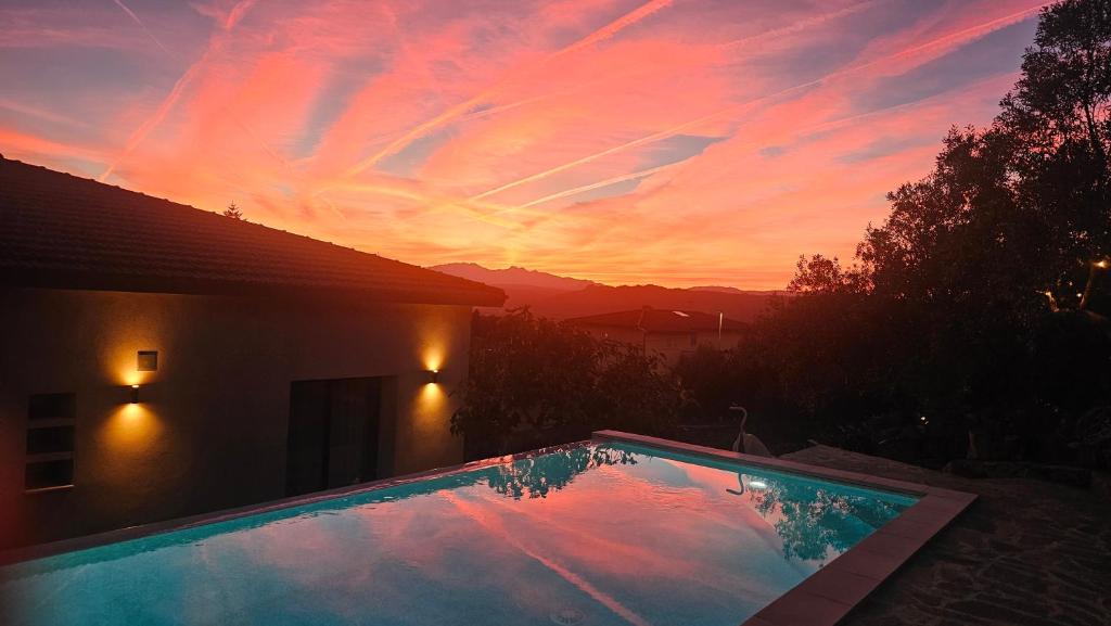 a swimming pool with a sunset in the background at Il 10 Settembre B&B in Enas
