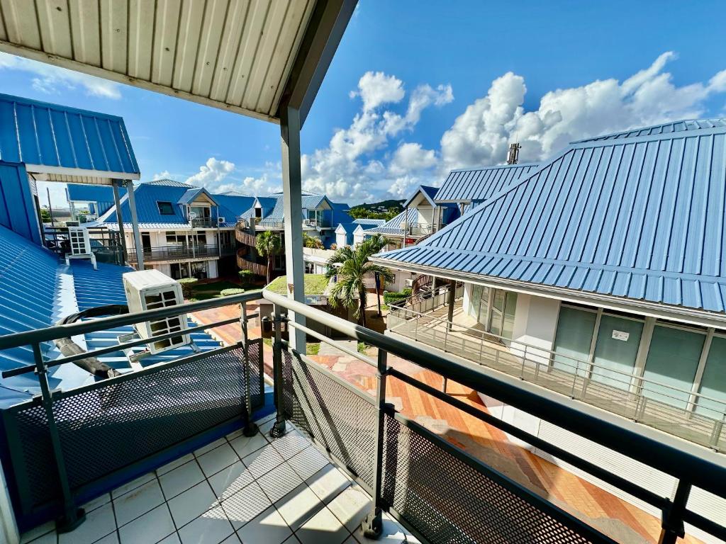 una vista dal balcone di una casa con il tetto blu di Large central 2 bedroom, ideal for family or pro stay a Marigot