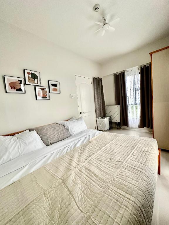 a bedroom with a large bed and a ceiling fan at Driftwood Nook in Dauis
