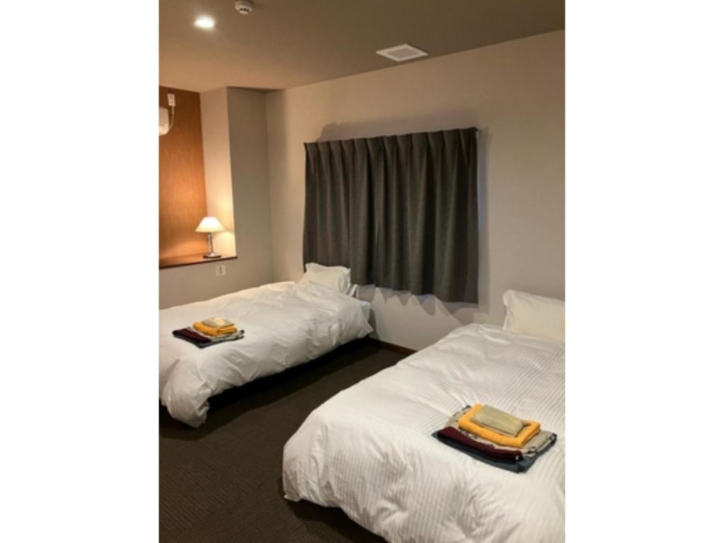 a hotel room with two beds with towels on them at Yahatakan - Vacation STAY 32425v in Sado