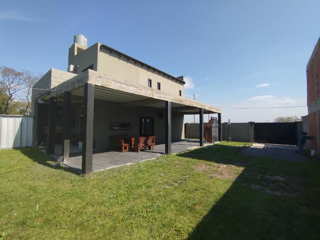 a building with two chairs in a yard at El rancho de la familia in Tristán Suárez