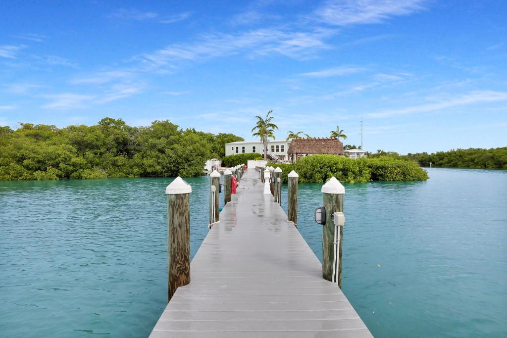 a dock in the middle of a lake with a house at Navigate Stays Private Home with Pool Hot-Tub & Dock in Crawl Key Number Two
