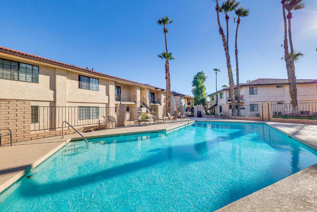 una piscina frente a un edificio con palmeras en Ground-Level Getaway 3 Mi to Bullhead City Parks, en Bullhead City