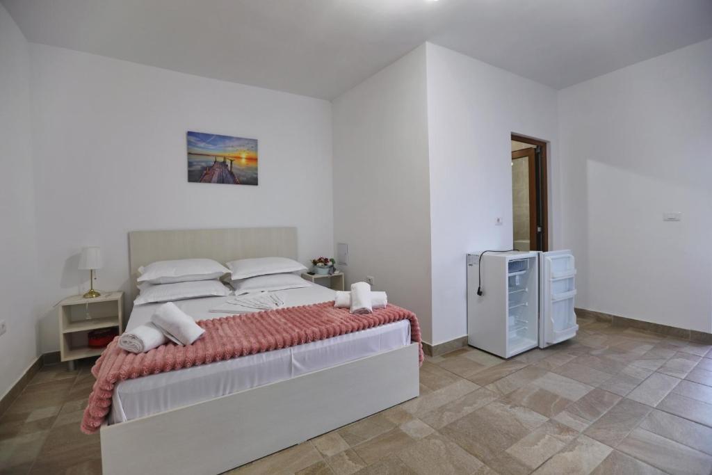a bedroom with a large bed and a refrigerator at Casa Selina in Corbu