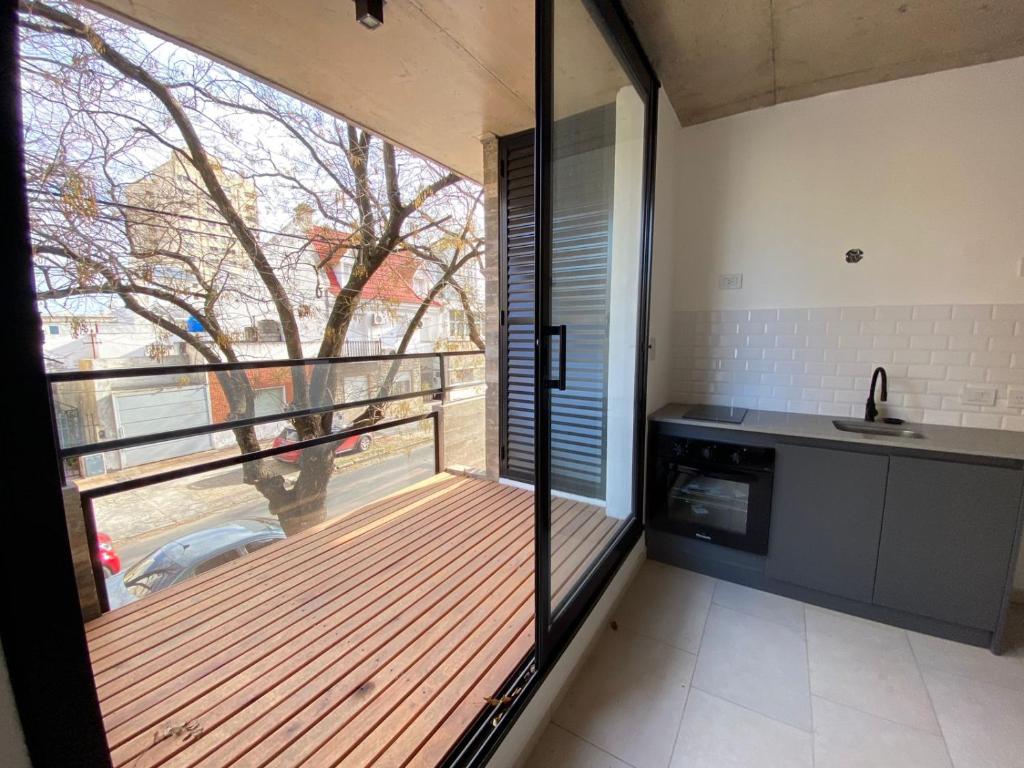 a kitchen with a large window and a kitchen with a sink at Monoambiente a estrenar con BALCÓN y DECK in La Plata