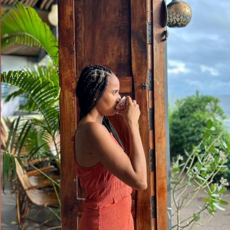 a woman in a red dress talking on a cell phone at Mad about Coco Yoga & Beach Retreat in Varkala