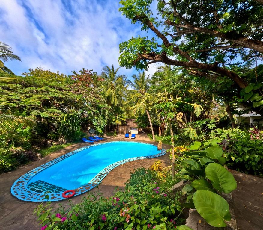 a swimming pool in the middle of a garden at Silver Rock Hotel in Malindi