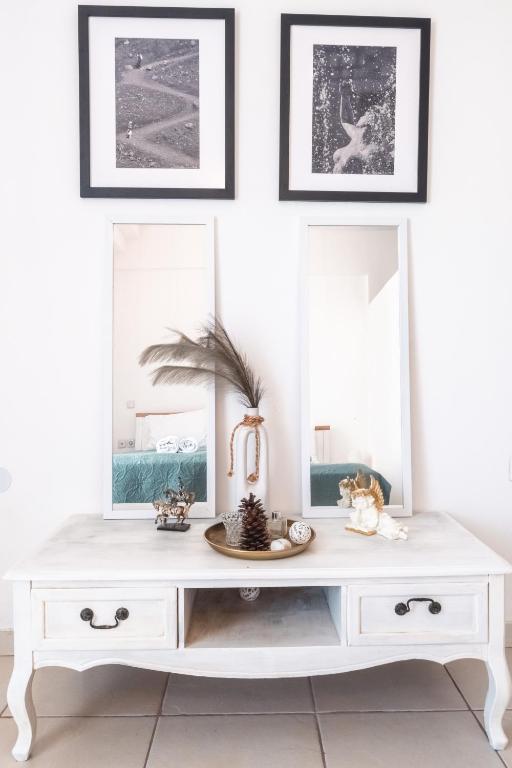 a white dresser in a room with three mirrors at comfort apartment in Tripoli