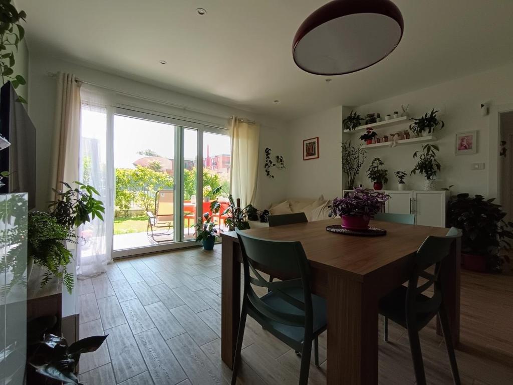 a dining room with a wooden table and a large window at Green Home in Rozzano