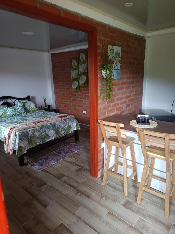 a bedroom with a bed and a table and chairs at Apartaestudio Queremal in Papagalleros
