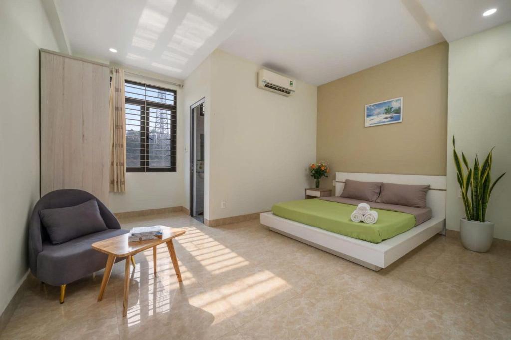 a bedroom with a bed and a chair and a table at Anh House 85 in Da Nang