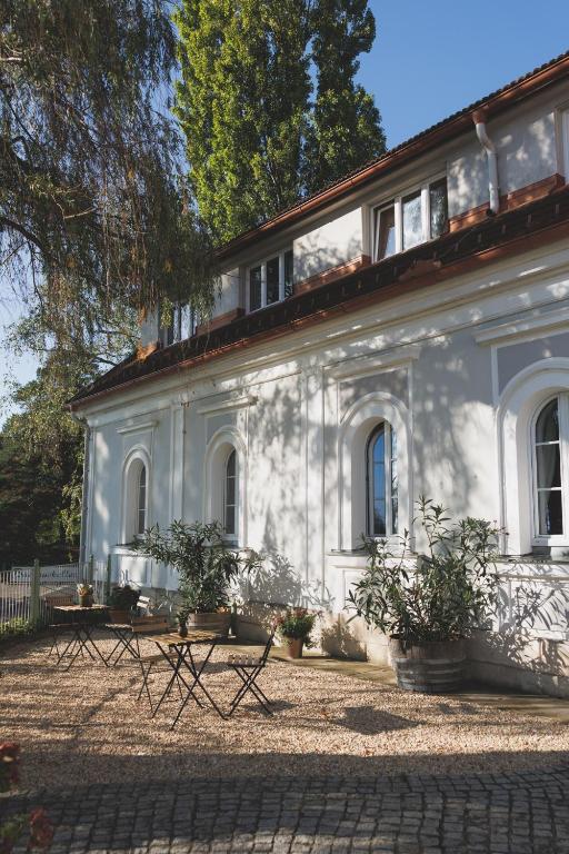 a white building with two picnic tables in front of it at Casa Firmenich in Eckberg