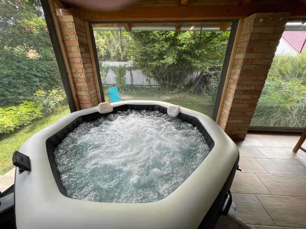 a jacuzzi tub in a room with a window at Rózsa Apartman Dombori in Fadd-Dombori