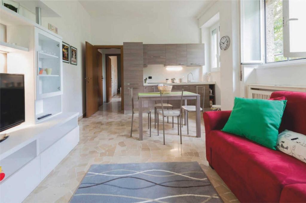 ミラノにあるMilano Colletta Apartmentのリビングルーム(赤いソファ、テーブル付)