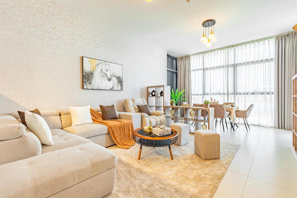a living room with a couch and a table at Amazing Rooftop Pool - Full Canal Views - 1 BDR - 5 min walk from Space42 Arena - Heart of Raha Beach in Abu Dhabi