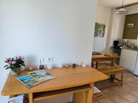 una cocina con una mesa de madera con flores. en Appartements indépendants dans chalet en Auvergne, en Chomelix