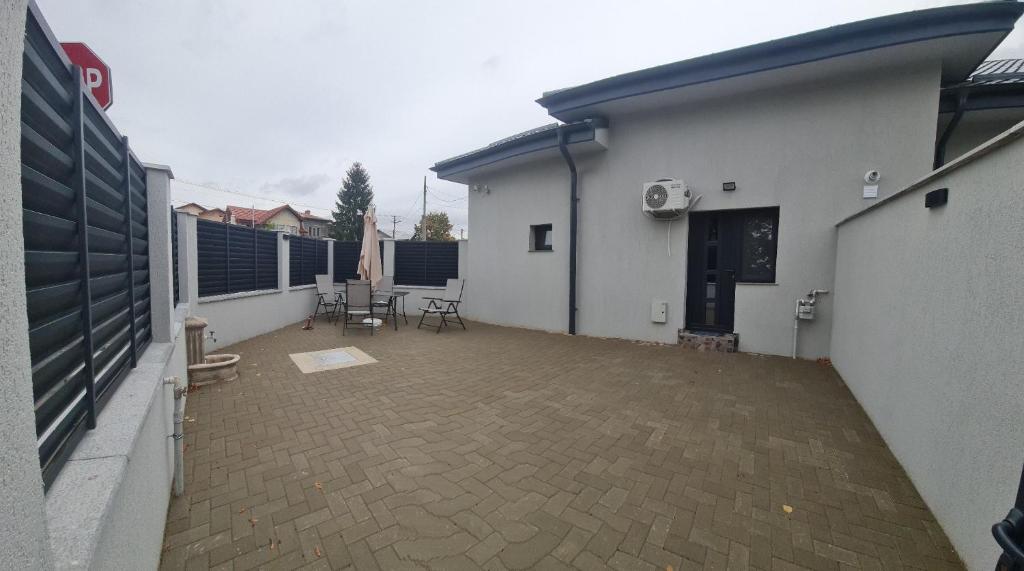 un patio con mesas y sillas junto a un edificio en Apartament Parc 1A, en Ploieşti
