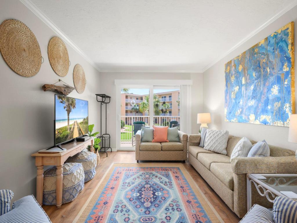 a living room with a couch and a tv at Beach Tennis 217 in Coquina Gables