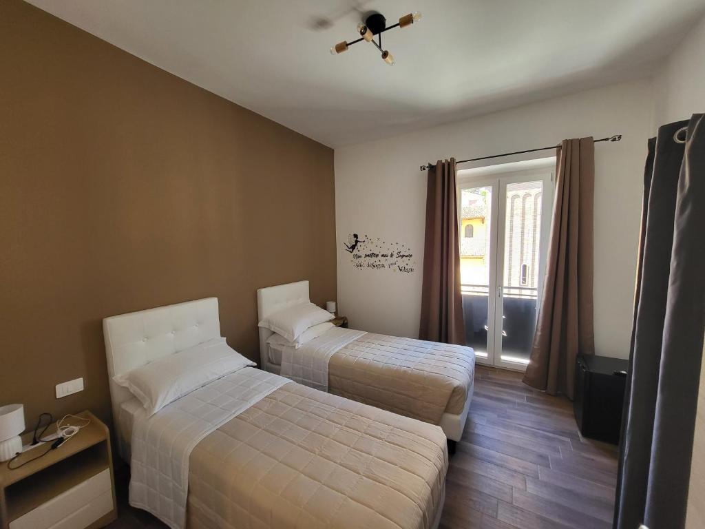 a hotel room with two beds and a window at B&B Sogno e Realtà in Carsoli
