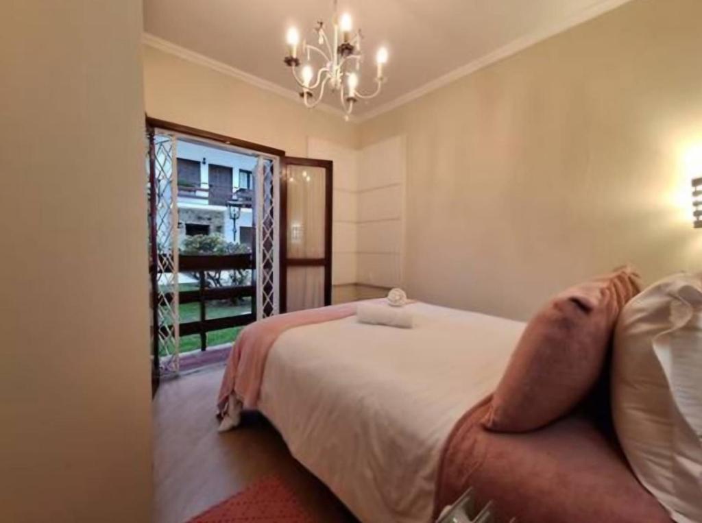 a bedroom with a bed and a large window at Capivari Flat in Campos do Jordão