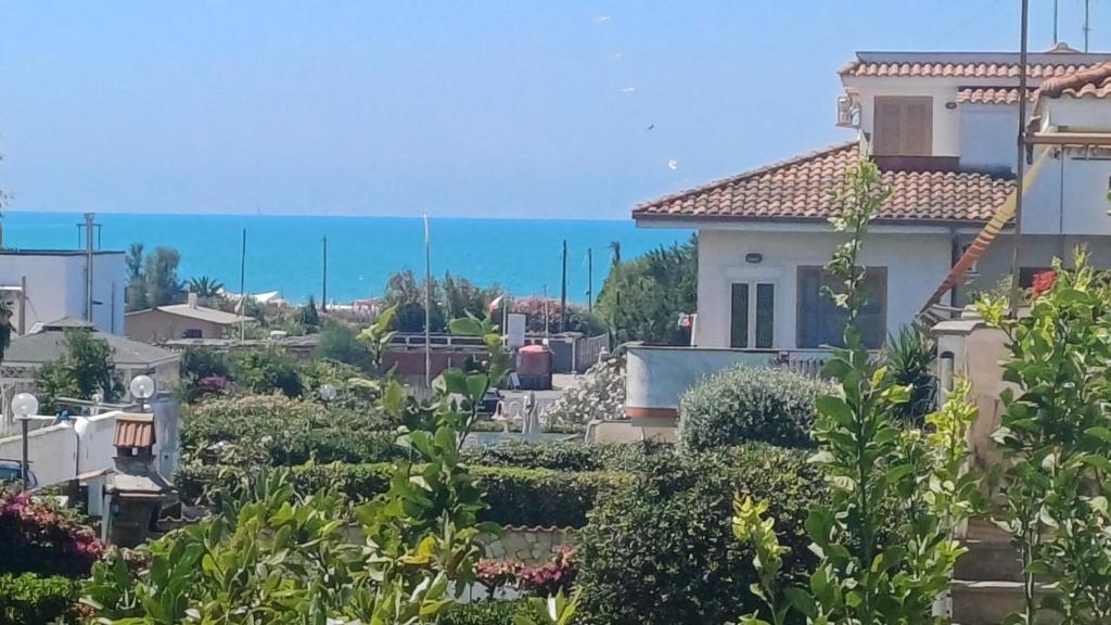 a view of a house with the ocean in the background at Ylenia Summer Beach in LʼAmericano