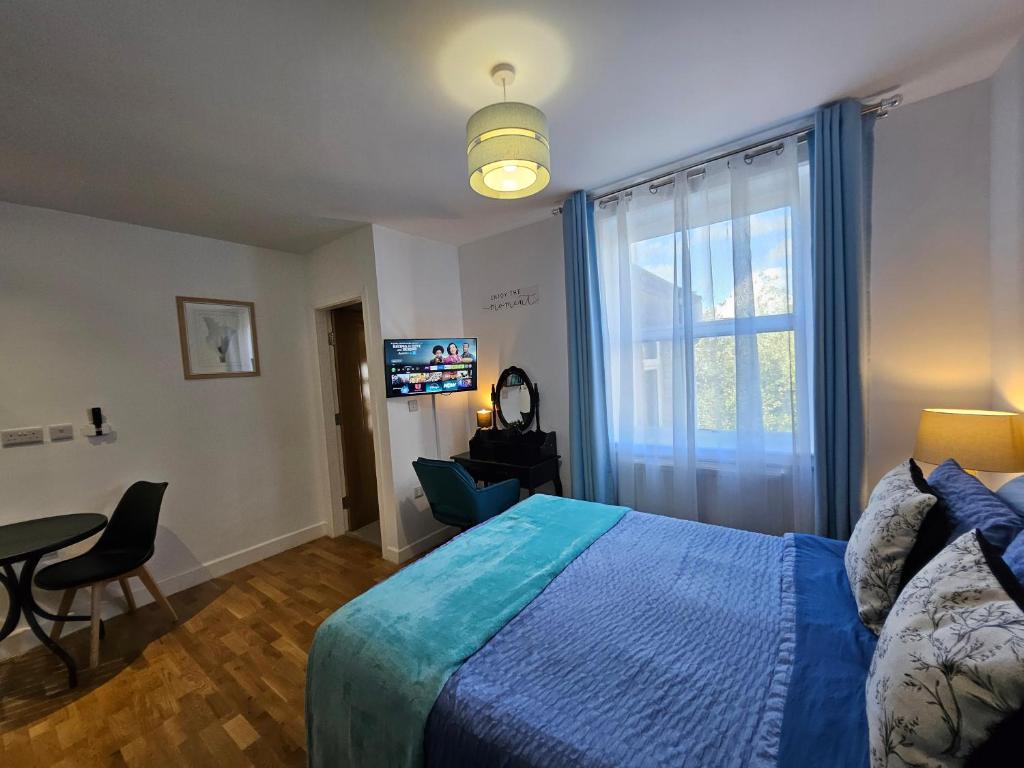 a bedroom with a bed and a table and a window at Central Chambers Suites - Suite 5 in Leek