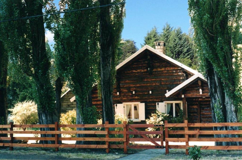 a log cabin with a fence in front of it at Alamos del Sur in San Martín de los Andes