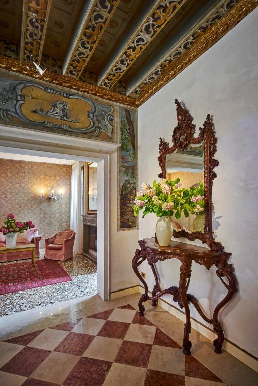 a room with a mirror and a table with flowers at Hotel Gardena in Venice