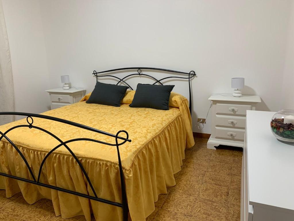 1 dormitorio con 1 cama con sábanas amarillas y 2 mesitas de noche en La Casa di Mia, en Vesime