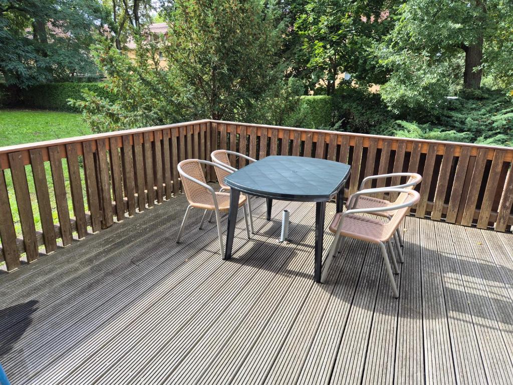a table and chairs on a wooden deck at Haus am Wendsee in Brandenburg an der Havel