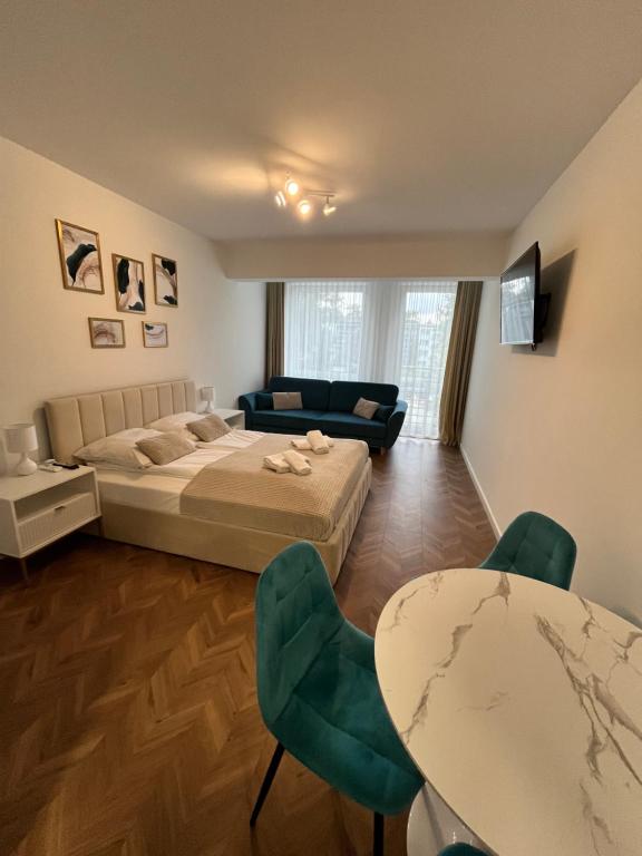 una camera da letto con un letto, un tavolo e delle sedie di PLANETA 106 - tylko 100 m do GŁÓWNEGO DEPTAKU i plaży! a Mielno