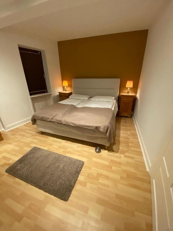 a bedroom with a bed and two night stands with lamps at Ferienwohnungen Zum Alten Buchbinder in Guntersblum