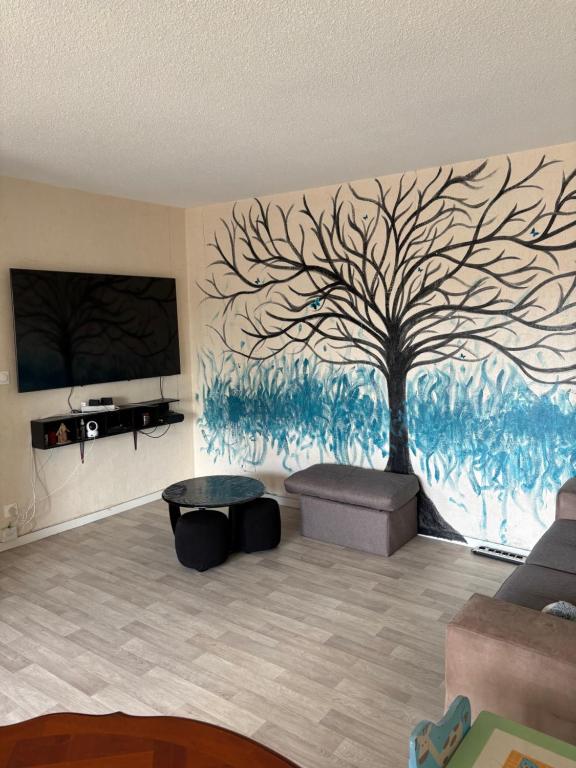 a living room with a tree mural on the wall at Appartement T3 - Blue Butterfly in Colomiers