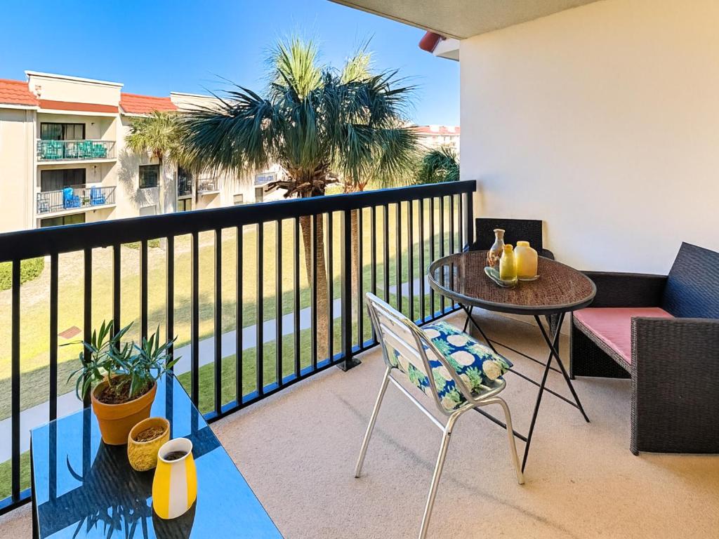 a balcony with a table and chairs and palm trees at Ocean Village Club P32 in Saint Augustine