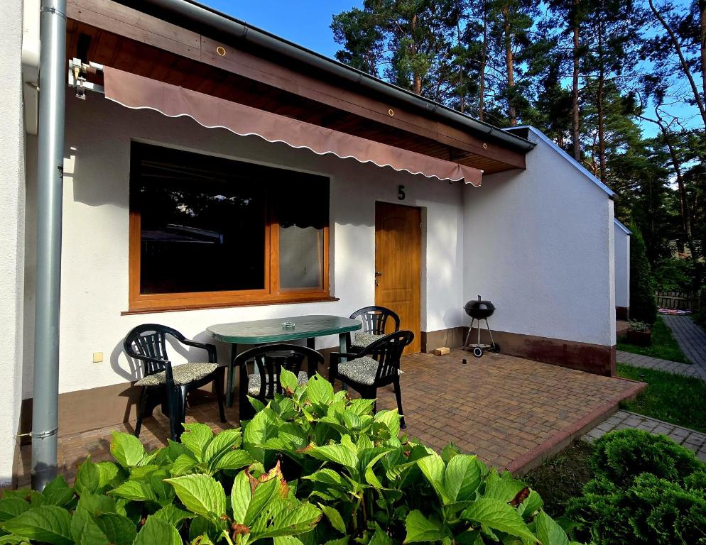 a patio with a table and chairs in front of a house at Monti Domki całoroczne in Mierzyn