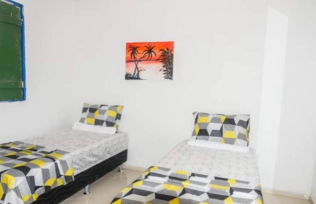a bedroom with two beds and a painting on the wall at Restaurante e Pousada Mandacaru Abacate in Campestre