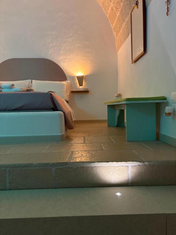 a bedroom with a bed and a table at Le Perle di Bà - Suites with Jacuzzi in Polignano in Polignano a Mare
