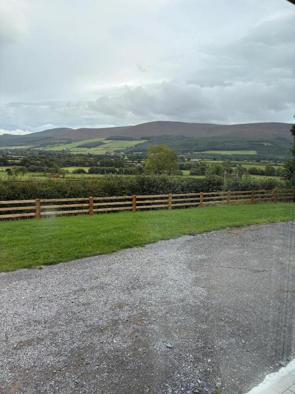 a fence on the side of a grassy field at Country Escape in Cloneen