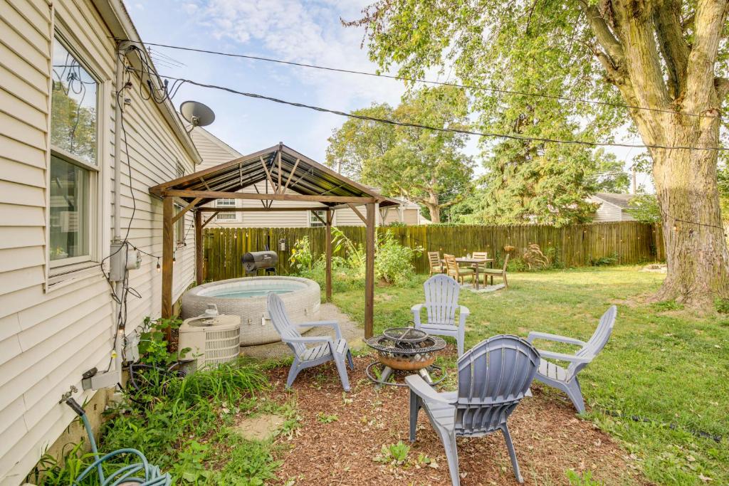 un patio trasero con parrilla, sillas y mesa en 2 Blocks to Main St Walkable Beech Grove Home!, en Beech Grove
