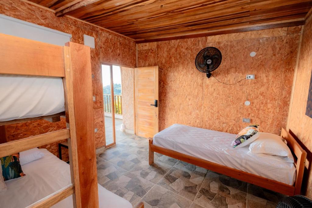 Un dormitorio con dos literas y una ventana. en Encanto, vista y aventura, en Minca