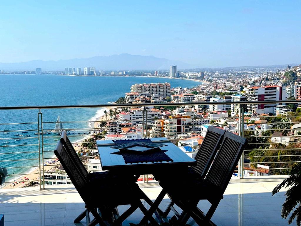 a table and two chairs on a balcony overlooking the ocean at 3-Bedroom Condo in the romantic zone in Puerto Vallarta