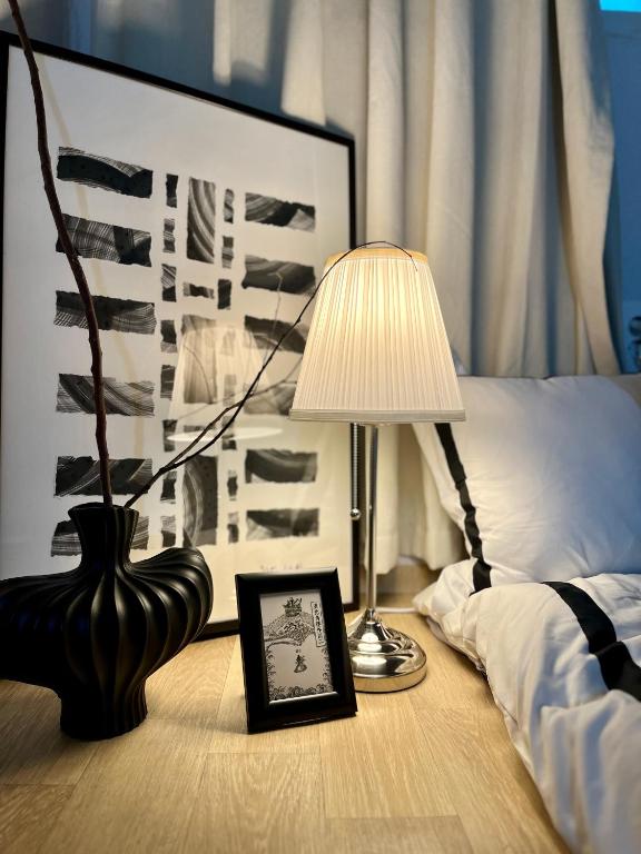 a lamp and a picture on a table next to a bed at Zen House Suwon Hwaseong in Suwon