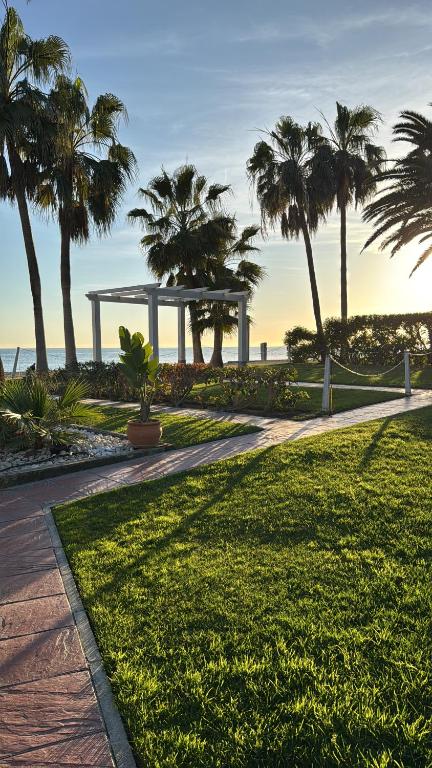 a park with palm trees and a pavilion on the beach at Apartamento Marinas de Nerja in Nerja