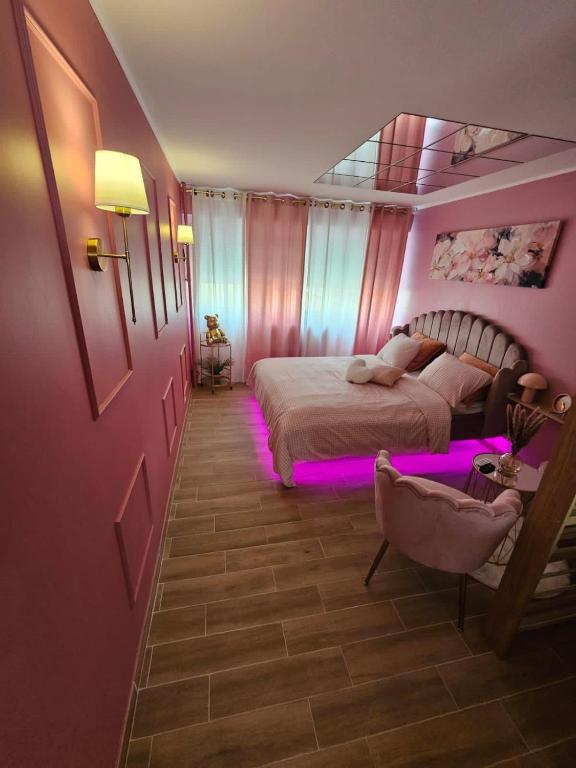 Le rêve rose في بيزنسون: غرفة نوم بها سرير مزين بأضواء أرجوانية