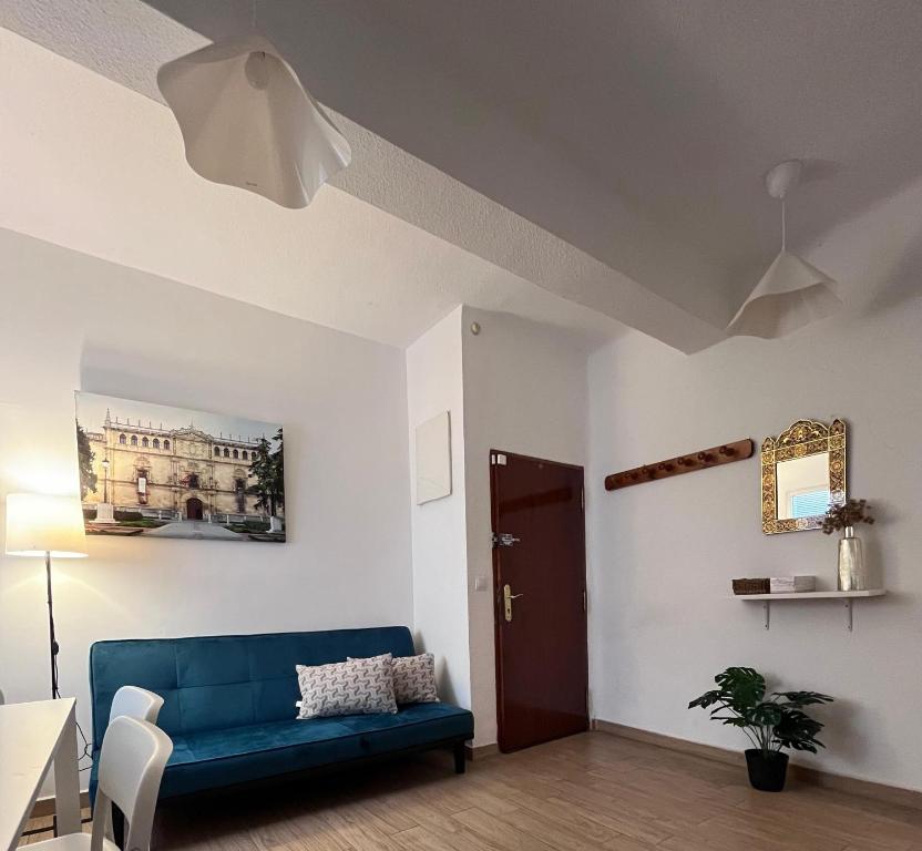 a living room with a blue couch and a table at El Atelier in Alcalá de Henares