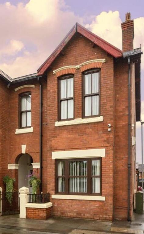 a red brick house with black windows at New Horizon Lodge in Leigh
