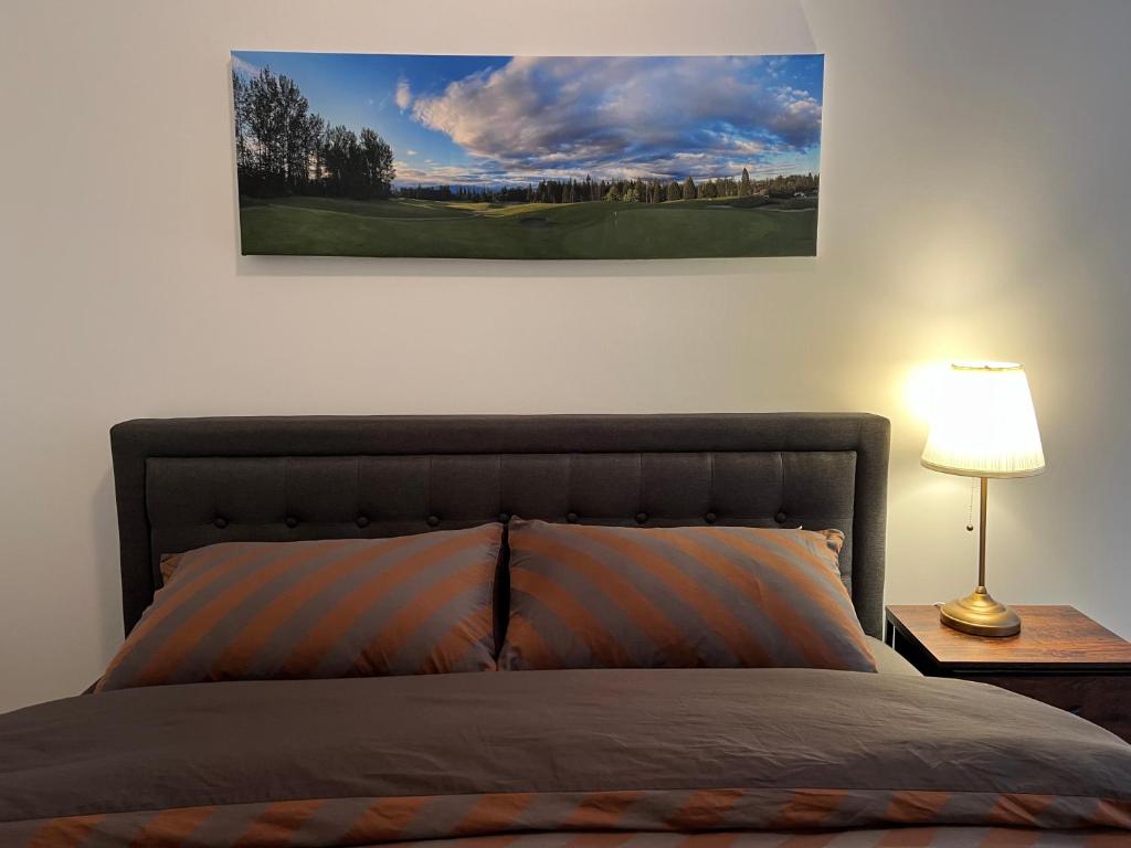 Modern 3-Bedroom Apartment in UBC في فانكوفر: غرفة نوم بها سرير وصورة على الحائط