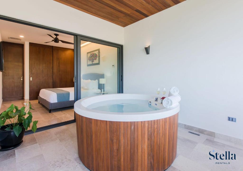eine Badewanne in einem Zimmer mit einem Schlafzimmer in der Unterkunft Condos with Private Jacuzzi and shared Ocean View Roof pool in Playa del Carmen
