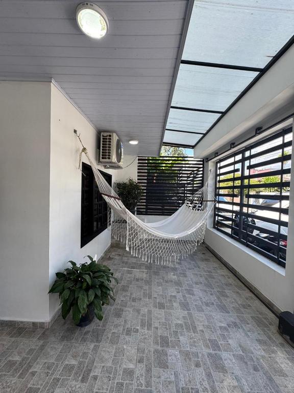 a room with a hammock in a building at Casa bonita y cómoda con antejardín Barrio Jardín 2-4 personas in Leticia