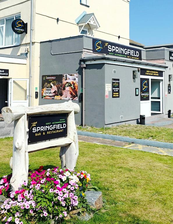 费尔伯恩The Springfield Hotel的一座建筑前种满鲜花的公园长凳